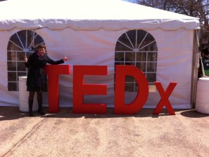 Karen posing by a TEDx sign