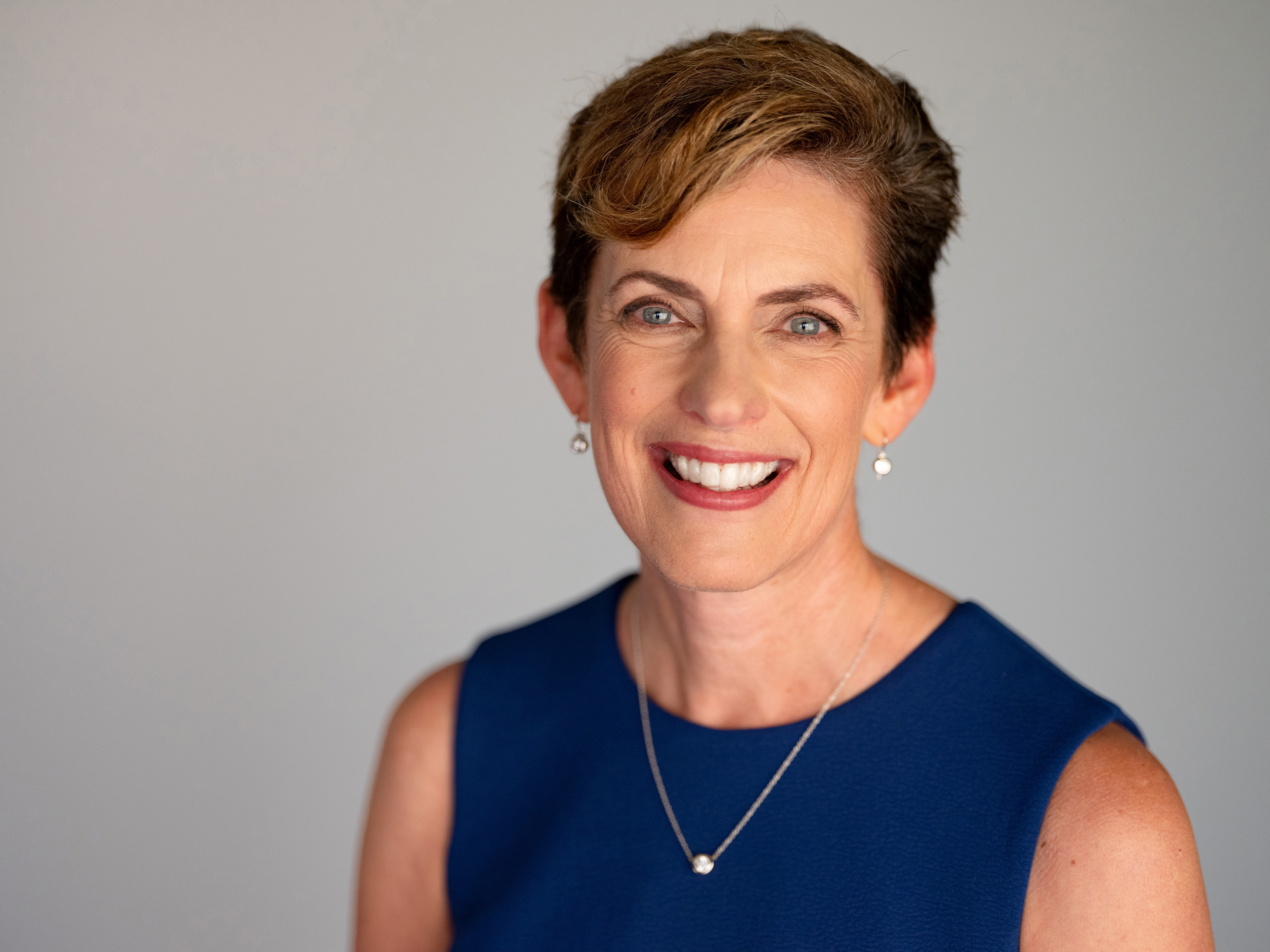 Photo of Karen Catlin, a white woman with a large smile and short brown hair.